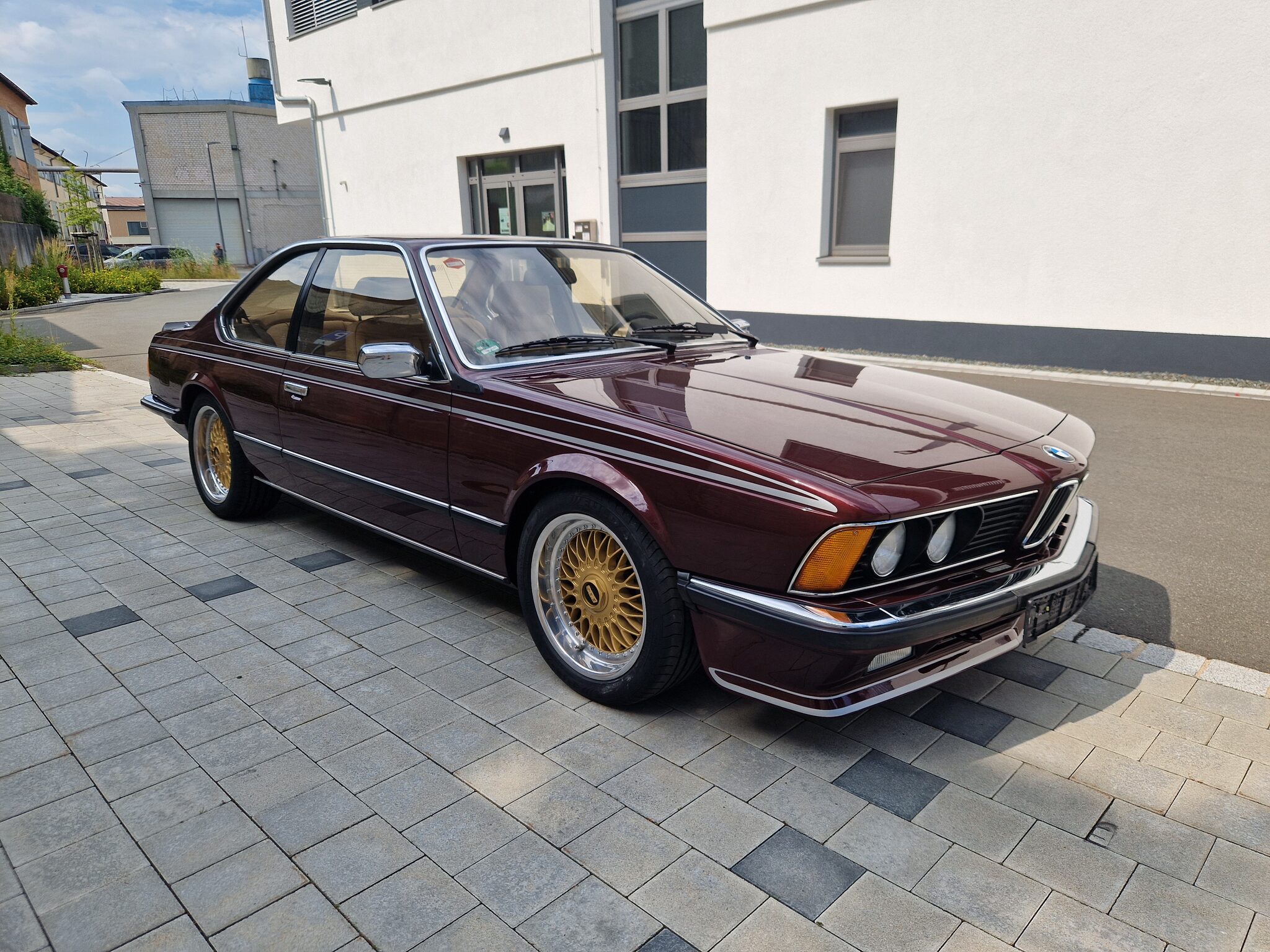 Derselbe bordeauxrote BMW 635CSi fertig, mit goldenen Kreuzspeichenfelgen