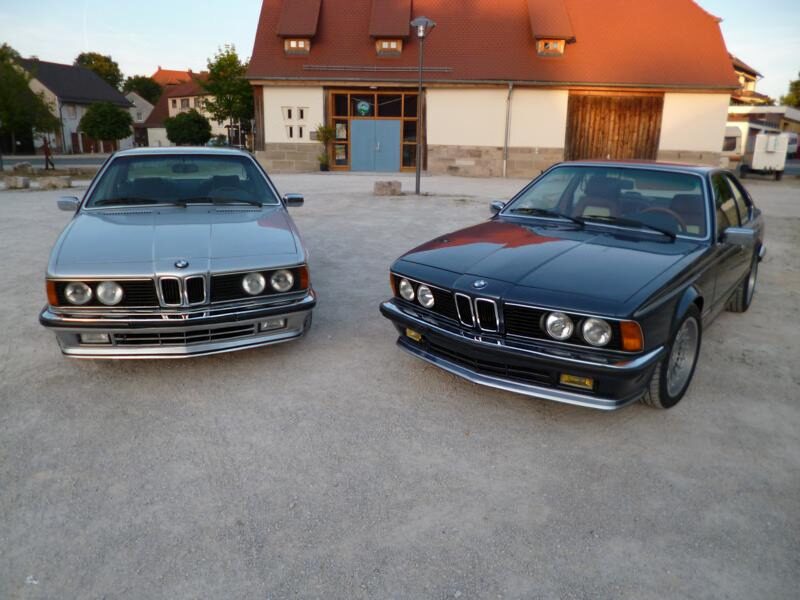Zwei BMW E24, silber und anthrazit, nebeneinander auf einem Platz